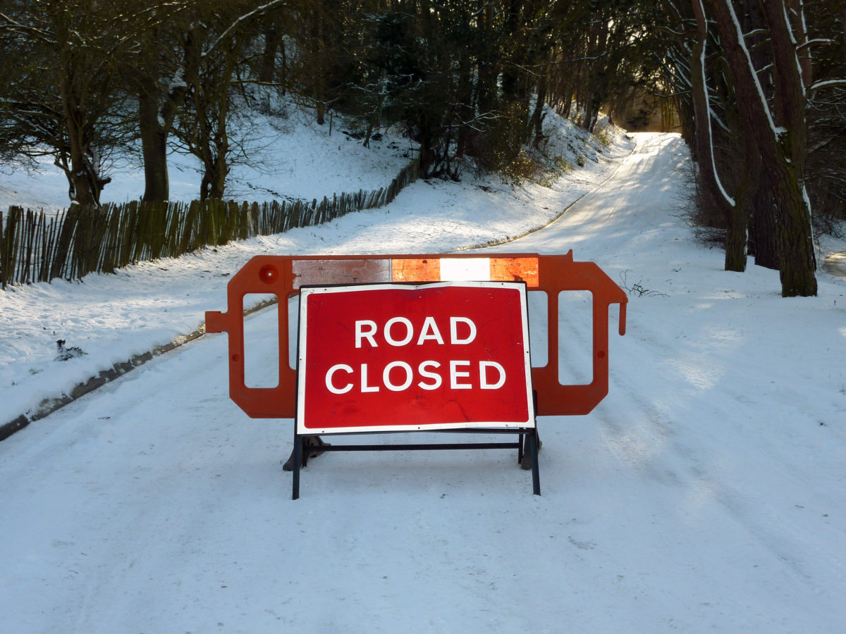 Road,Closed,Sign,Bars,Traffic,From,Snow,Covered,Road